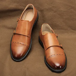 Dettaglio scarpe monk in pelle marrone con doppia fibbia e decorazioni a coda rondine