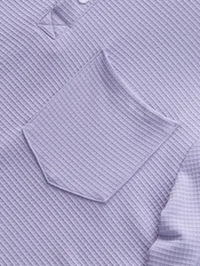 Macro view of purple waffle knit fabric and chest pocket on a casual Henley shirt