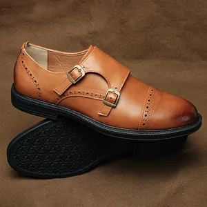 Dettaglio delle scarpe monk doppie da uomo in pelle marrone con decorazioni brogue
