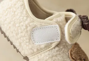Detaillierte Makroaufnahme des weichen Plüschmaterials und Klettverschlusses am Babyschuh