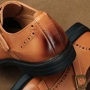 Dettaglio ravvicinato di scarpe Monk Strap in pelle marrone con motivi brogue e cuciture