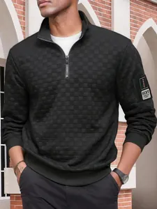 Primo piano del pullover tattico nero da uomo con texture a scacchi e collo con zip.