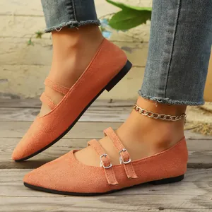 Gros plan de ballerines Mary Jane orange à bout pointu et doubles boucles aux pieds.