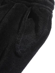 Macro shot showing the soft black fleece material and pocket detail of the hoodie