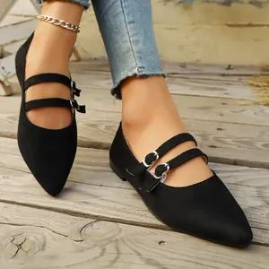 Vue détaillée de chaussures Mary Jane noires à bout pointu et doubles boucles sur bois.