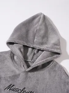 Detailed view of soft grey fleece hoodie featuring black muscle embroidery on chest area