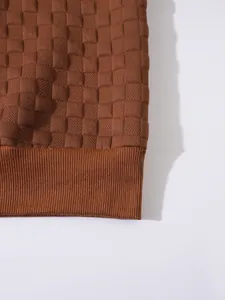 Dettaglio macro della giacca tattica in pile marrone con trama a scacchi e bordo a coste