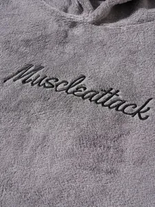 Detailed macro view of black Muscleattack embroidery on grey soft fleece hoodie