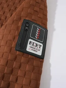 Dettaglio della manica della felpa tattica trapuntata marrone con tasca e patch zip