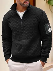 Dettaglio ravvicinato del pullover tattico in pile a scacchi neri con toppa sulla manica