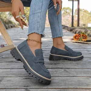 Close-up of women's matte grey loafers with thick lug soles in an outdoor setting