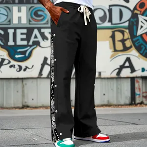 Detailed close-up of men's black snap-button track pants with bandana pattern panels