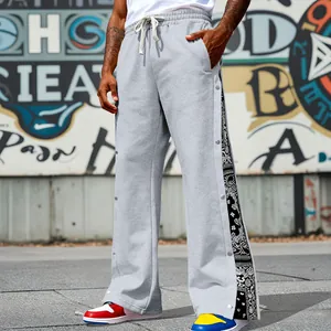 Detail of grey sweatpants featuring side snap buttons and paisley print panels