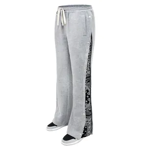Close-up view of gray sweatpants featuring side snap buttons and a paisley pattern lining