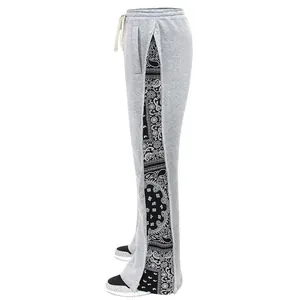 Detail of grey sweatpants featuring side snap buttons and black bandana print panel