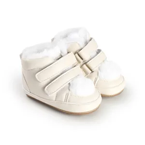 Detail view of warm beige baby winter boots with white faux fur lining and Velcro straps.
