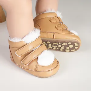 Detailed view of warm brown baby winter boots with white fur trim and non-slip soles.