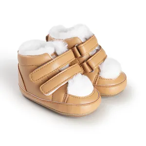 Close-up of warm winter baby boots with white faux fur lining and pom-pom detail