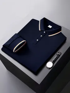 Polo à manches longues bleu marine plié avec col rayé et montre élégante sur bloc