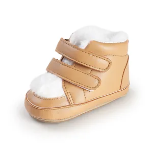 Detail view of tan baby boots with soft white fur lining and double velcro straps