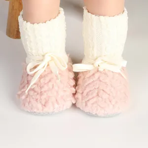 Dettaglio di stivaletti invernali rosa in peluche per neonati con polsini bianchi.