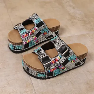 Close-up detail of women's platform sandals with colorful beads and sparkly rhinestones