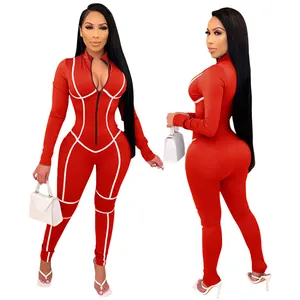 Détail d'une combinaison sexy rouge à manches longues avec passepoil blanc contrasté.