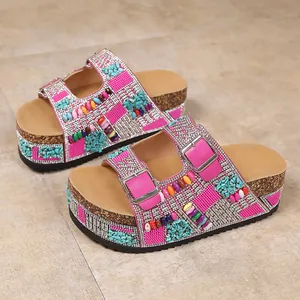 Detail view of pink platform sandals with vibrant rhinestone and bead embellishments