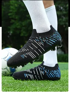Detailed side view of professional black and blue soccer cleats with long spikes on grass field