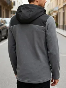 Back view of a men's grey and black colorblock fleece hooded jacket in an urban setting
