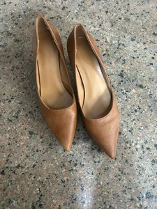 Detalle de zapatos de tacón marrón con punta fina y estilo retro francés.