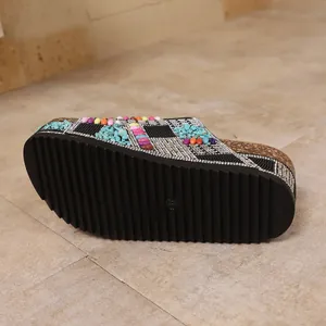 Detailed view of thick black sole and rhinestone decoration on platform sandal