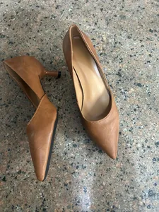 Detalle de zapatos de tacón bajo marrón con punta fina y diseño retro francés.