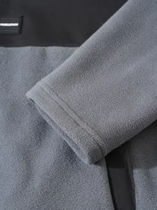 Detailansicht aus grauem Polarfleece-Material und genähter Manschette an Herrenjacke