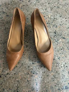 Una vista superior de un par de elegantes zapatos de salón marrones con punta para mujer