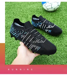 Detailed view of black professional soccer cleats with traction studs on grass