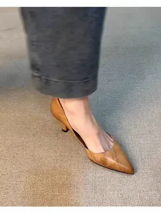 Detalle de elegantes zapatos de tacón bajo en cuero marrón con punta afilada