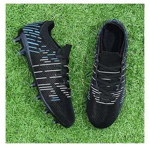 Professional black and blue outdoor soccer cleats shown in detail on artificial green turf.