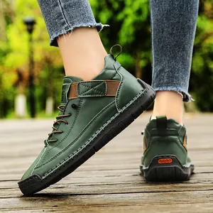 Detailed view of dark green mid-top men's Martin boots with heavy workwear stitching