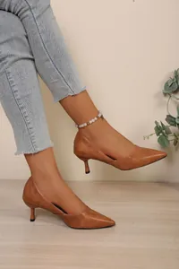 Elegantes zapatos de salón marrones con punta fina y tacón de gatito estilo retro chic.