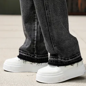 Dettaglio ravvicinato dell'orlo a vivo di questi pantaloni cargo in denim scuro lavato