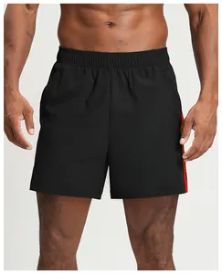 Close-up of men's quick-dry black sports shorts with orange side stripe detail