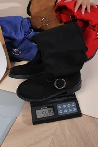 Detailaufnahme eines schwarzen Wildlederstiefels auf einer digitalen Waage 559g