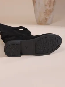 Nahaufnahme der rutschfesten Gummisohle schwarzer Wildleder-Slouch-Boots mit Größenmarkierung 37