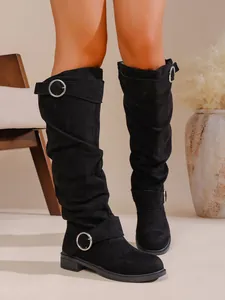 Detail von schwarzen Wildleder-Slouch-Stiefeln mit Silberschnalle und Blockabsatz
