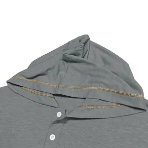 Détail de près d'un t-shirt Henley gris à capuche avec coutures contrastées