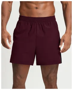 Detail view of burgundy men's quick-dry athletic shorts with black side stripe