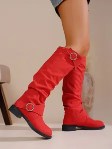 Auffällige rote Wildleder-Stiefel im Slouch-Look mit Schnallendetails und niedrigem Blockabsatz.