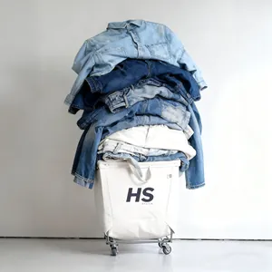 A stack of vintage American-style denim jeans and jackets in a laundry basket.