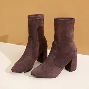 Elegante dunkelbraune Wildleder-Stiefeletten mit spitzer Kappe und klobigem Blockabsatz.